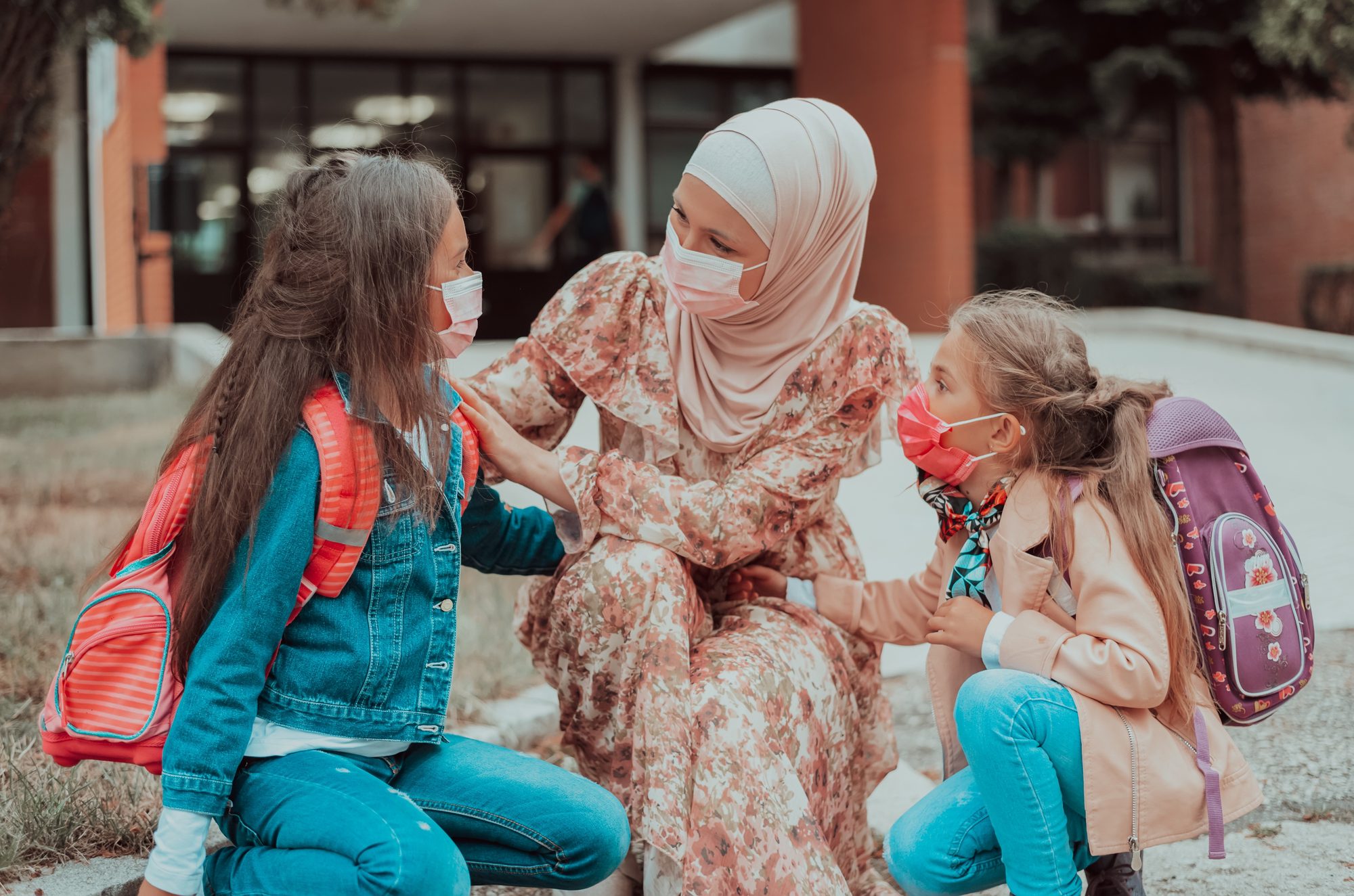Young Mother in Hijab Arriving Child Daughters to School.