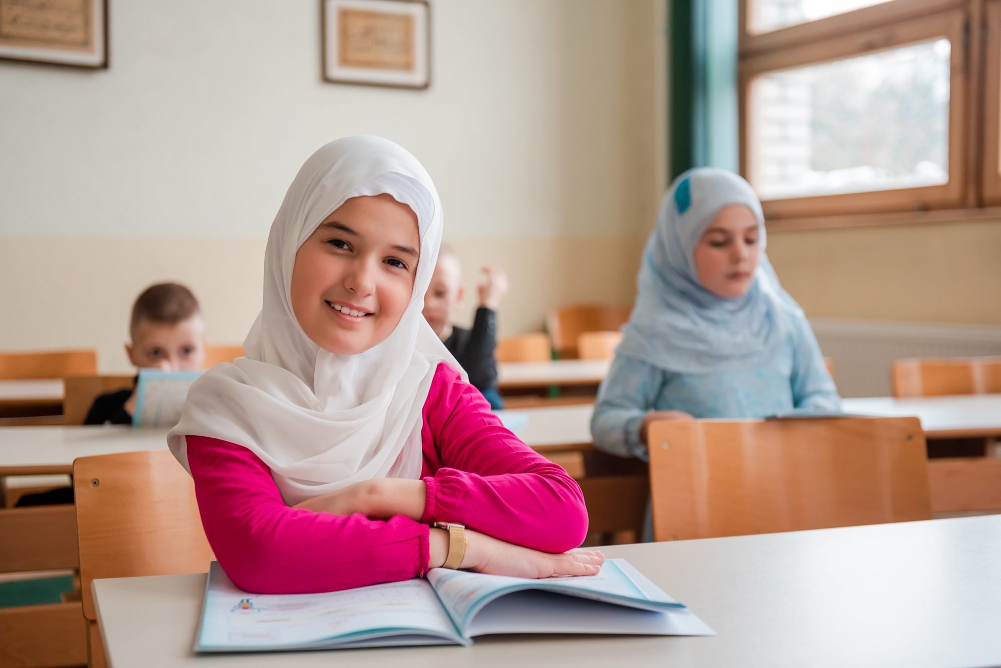 Group of Muslim Children Students Sitting at the School Desk in the Classroom During the Class.